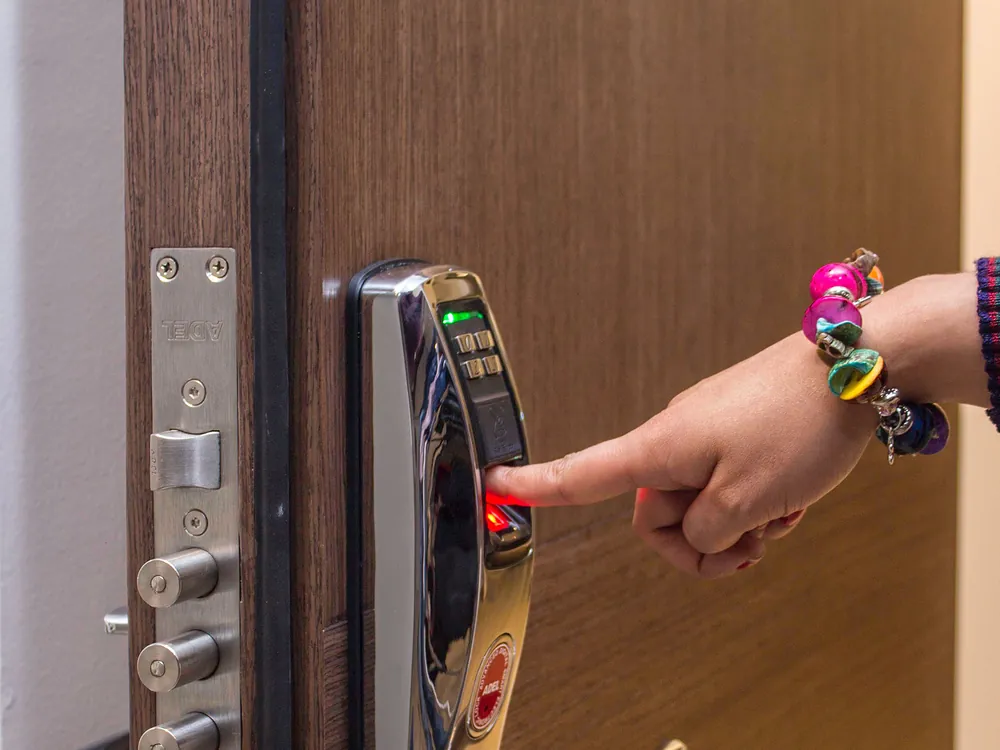 A finger on the fingerprint reader of a smart door lock