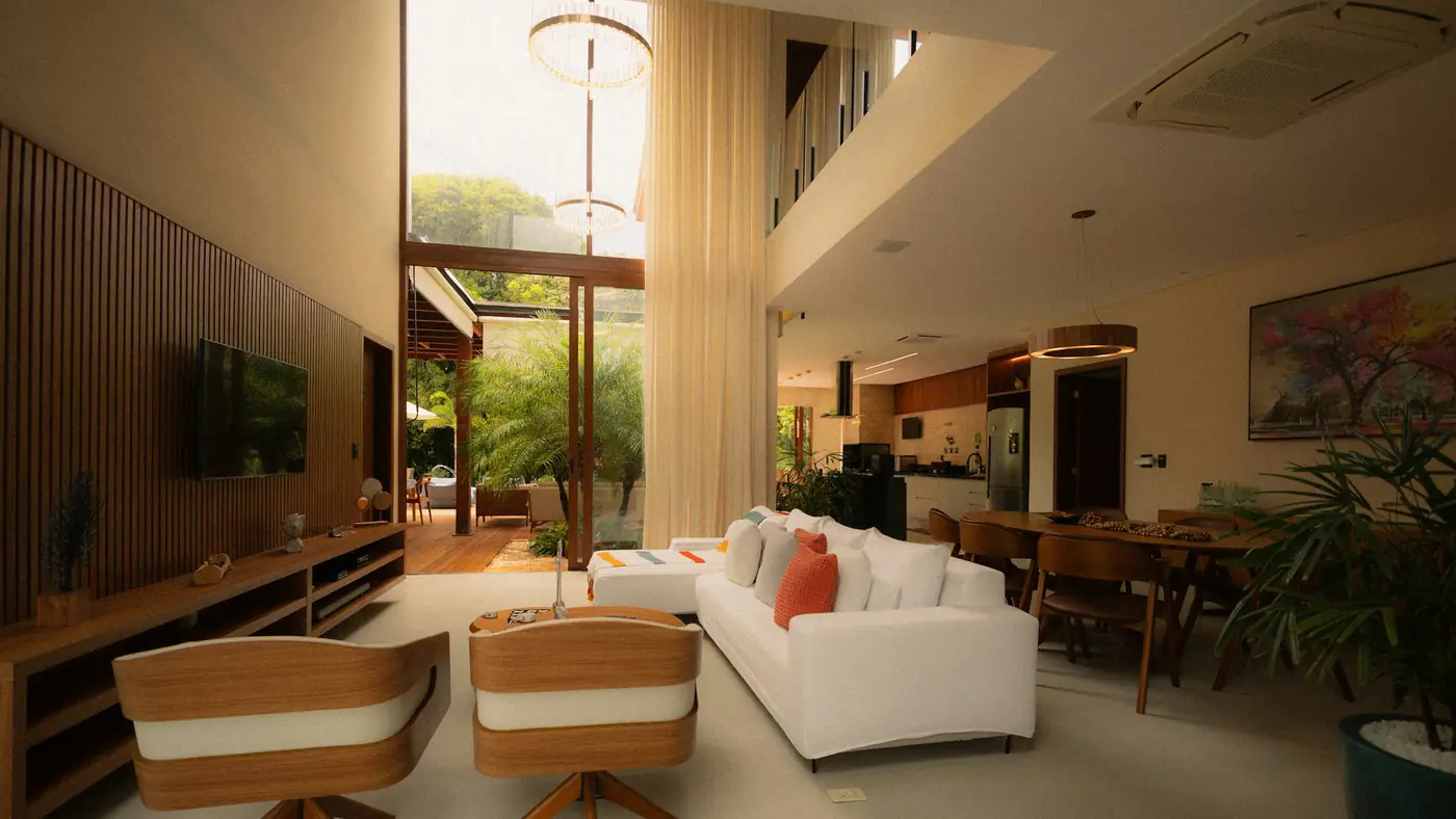 A double-height villa living room opening onto a garden courtyard